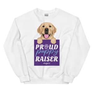 A white crew neck sweatshirt with an illustrated yellow Labrador puppy and the text Proud Puppy Raiser in a purple square.
