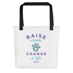 A white tote bag with a graphic paw print and 'Raise a Puppy Change a Life' text in purple and blue.