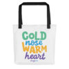 A white tote bag with 'Cold Nose Warm Heart' graphic text in green, blue, yellow, and purple.