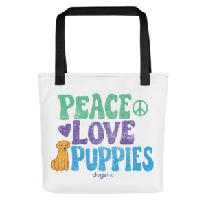 A white tote bag with a dog graphic and 'Peace Love Puppies' text in green, purple, and blue.