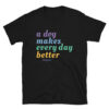 A black unisex t-shirt with 'A Dog Makes Every Day Better' graphic text in purple, blue, green, and yellow.