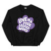 A black crewneck with 'Love is a Four Legged Word' text inside a purple paw print graphic.