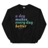 A black crewneck with 'A Dog Makes Every Day Better' graphic text in purple, blue, green, and yellow.