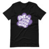 A black unisex t-shirt with 'Love is a Four Legged Word" text inside a purple paw print graphic.