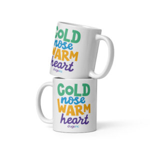 A white coffee mug with 'Cold Nose Warm Heart' graphic text in green, blue, yellow, and purple.