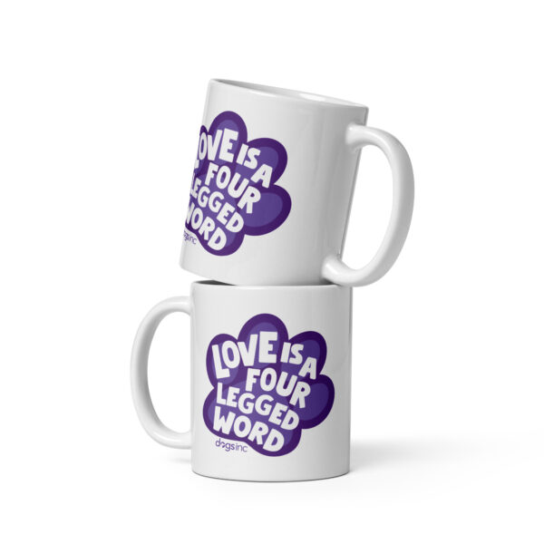A white coffee mug with 'Love is a Four Legged Word" text inside a purple paw print graphic.