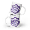 A white coffee mug with 'Love is a Four Legged Word" text inside a purple paw print graphic.