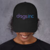 A black dad hat with the Dogs Inc logo embroidered in purple and blue.