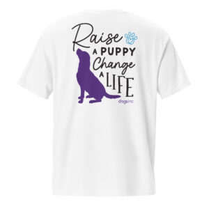 The back of a white unisex t-shirt with a dog graphic in purple and 'Raise a Puppy Change a Life' text in black.