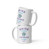 A white coffee mug with a graphic paw print and 'Raise a Puppy Change a Life' text in purple and blue.