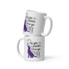 A white coffee mug with a dog graphic in purple and 'Raise a Puppy Change a Life' text in black.