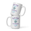 A white coffee mug with a graphic paw print and 'Raise a Puppy Change a Life' text in purple and blue.